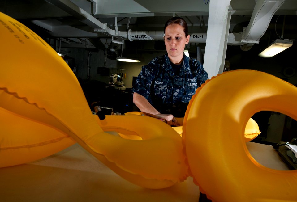 US Navy 111214-N-DR144-030 Aircrew Survival Equipmentman 2nd Class Emilie Mincher deflates air bladders on LPU-34B-P low-profile floatation collars