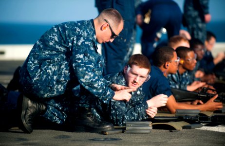US Navy 111210-N-PB383-563 Chief Gunner's Mate Frank Smith instructs Logistics Specialist 2nd Class David Elliot during small arms qualifications a