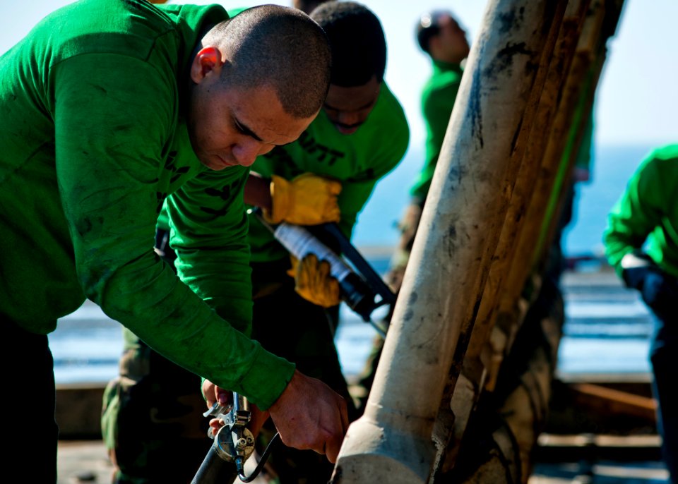 US Navy 111213-N-BT887-109 Sailors perform maintenance on a jet blast deflector aboard the Nimitz-class aircraft carrier USS John C. Stennis (CVN 7