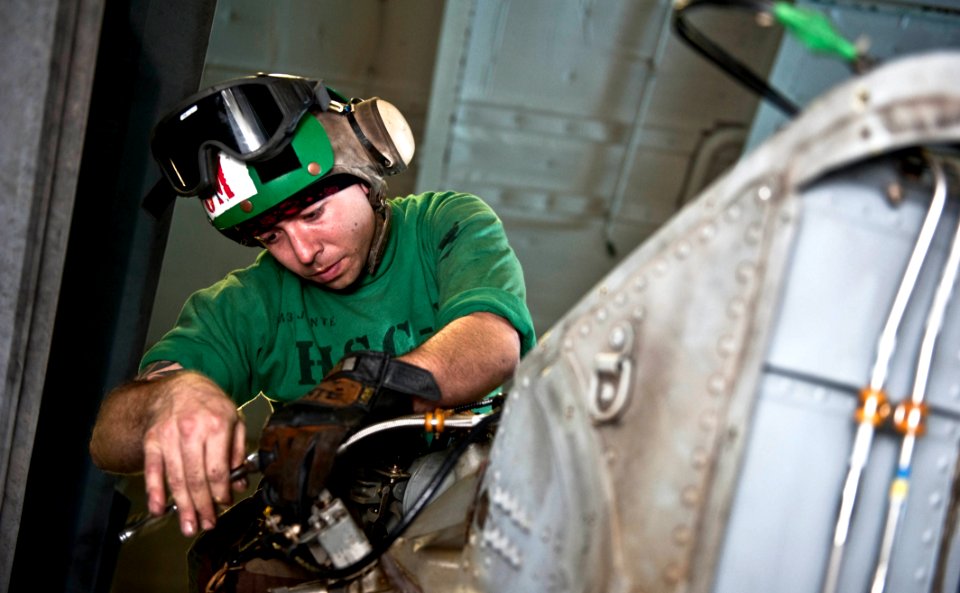 US Navy 111213-N-GC412-217 A Sailor performs maintenance on the tail rotor servo on a helicopter