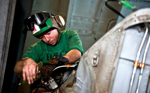 US Navy 111213-N-GC412-217 A Sailor performs maintenance on the tail rotor servo on a helicopter