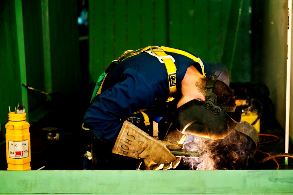 US Navy 111214-N-BT887-496 A Sailor welds the edge of a storage unit