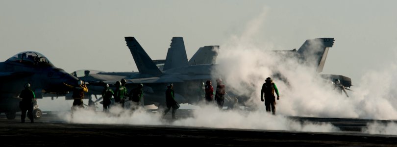 US Navy 111214-N-OY799-097 Sailors directs aircraft into position during flight operations on the flight deck of the Nimitz-class aircraft carrier