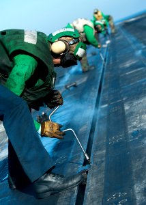 US Navy 111214-N-BT887-162 Sailors install buttons into the slot of a steam-powered catapult track aboard the Nimitz-class aircraft carrier USS Joh