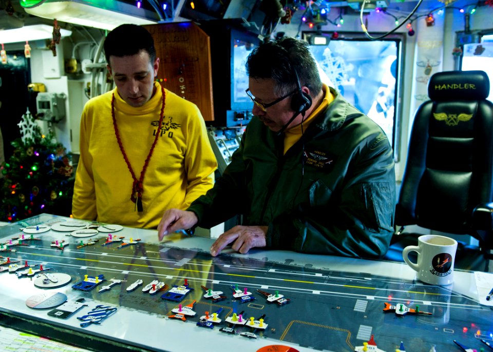 US Navy 111215-N-BT887-008 Flight Deck Handler Lt. Cmdr. Edward Jaso maps out aircraft placement on the Ouija board aboard the Nimitz-class aircraf