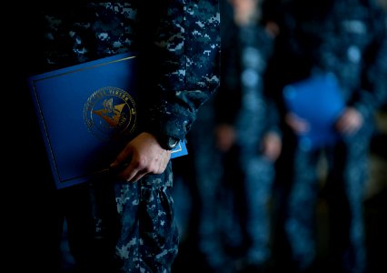 US Navy 111213-N-DR144-360 Newly promoted petty officers wait with their frocking letters to take the stage during a frocking ceremony in the hanga