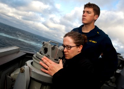 US Navy 111213-N-FI736-028 Ensign Bryan Wilson watches as Lt. Danielle Litchford uses an alidade to find the distance between USNS Supply (T-AOE 6