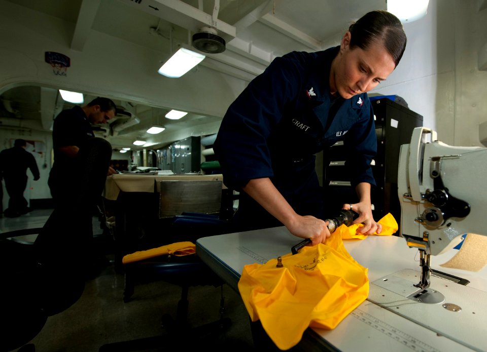US Navy 111214-N-DR144-047 Aircrew Survival Equipmentman 3rd Class Haley Craft deflates air bladders for LPU-34B-P low-profile floatation collars i