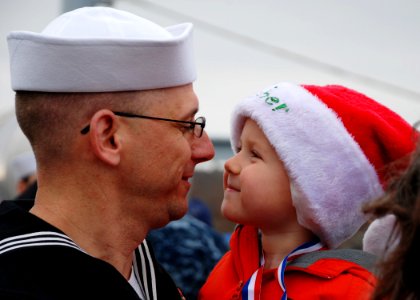 US Navy 111215-N-AW342-159 Electronics Technician 1st Class Joel Watson holds his son after returning from a five-month deployment aboard the Los A