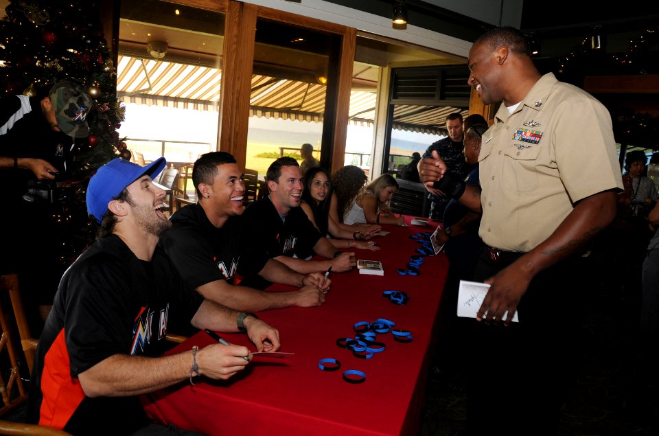 US Navy 111213-N-YU572-026 Culinary Specialist 1st Class Michael Sanders jokes with members of the Miami Marlins baseball team