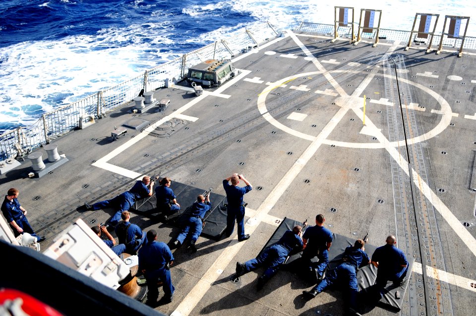 US Navy 111213-N-ZF681-525 Sailors fire the M4A1 carbines during small arms qualifications on the flight deck of the guided-missile destroyer USS H