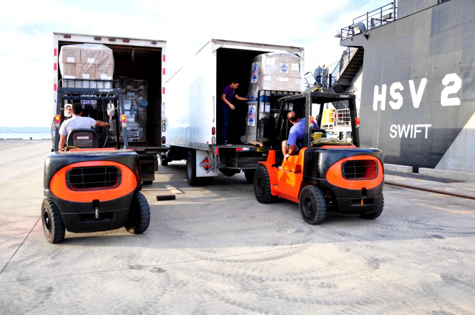 US Navy 111214-A-TF780-112 Donated goods for Project Handclasp are loaded onto trucks next to High Speed Vessel (HSV 2) Swift as part of Southern P
