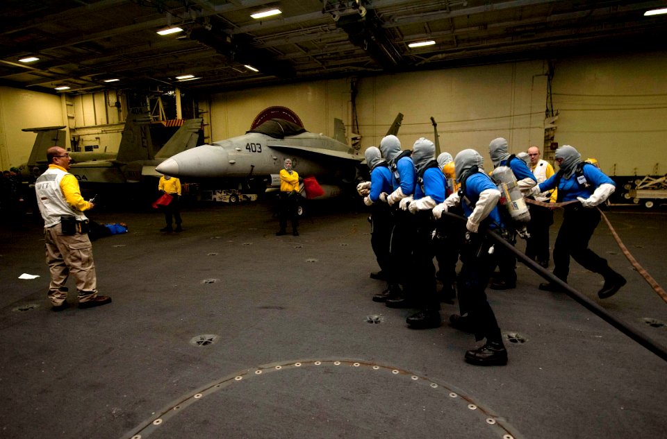 US Navy 111217-N-JN664-030 Sailors participate in an aircraft fire drill in the hangar bay of the Nimitz-class aircraft carrier USS Abraham Lincoln