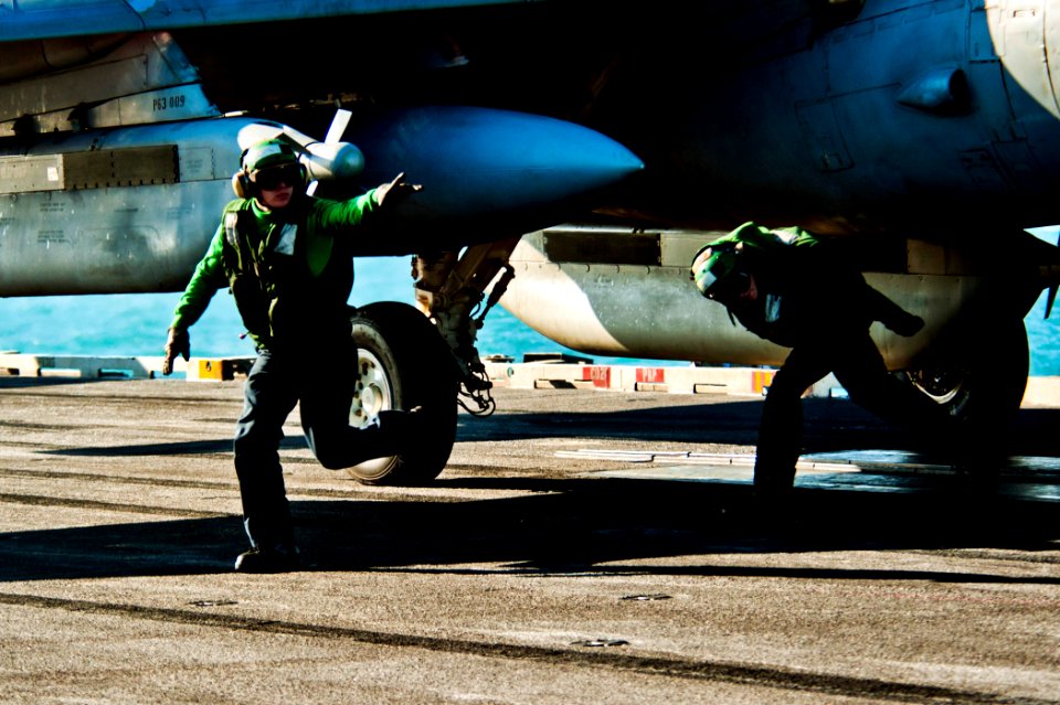 US Navy 111214-N-BT887-058 Aviation Boatswain's Mate (Equipment) 3rd Class Chord Deckert clears the launch area before launching aircraft aboard th