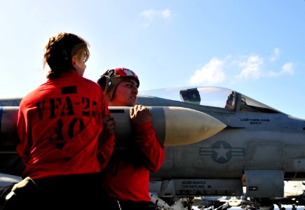 US Navy 111219-N-ZI635-041 Aviation ordnancemen, assigned to Strike Fighter Squadron (VFA) 25, move ordnance on the flight deck of the Nimitz-class