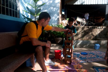 US Navy 111215-N-PB383-017 ngineman 2nd Class Jeffery Griffiths plays a game with children during a community relations event at the Help the Cambo
