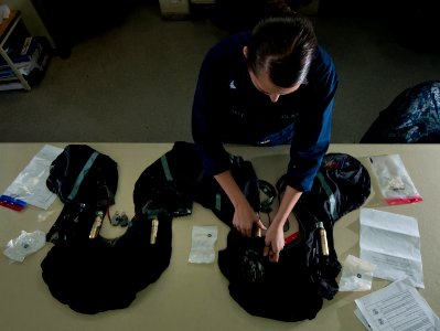 US Navy 111214-N-DR144-027 Aircrew Survival Equipmentman 3rd Class Haley Craft repacks LPU-34B-P low-profile floatation collars after a 360-day ins