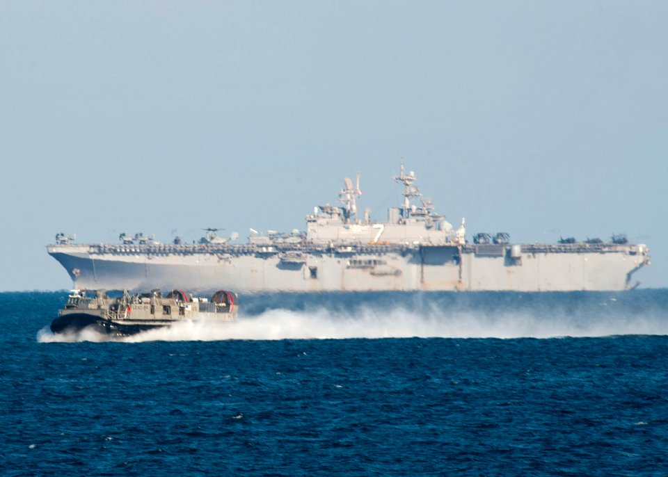 US Navy 111218-N-NR955-069 A landing craft air cushion passing the multi-purpose amphibious assault ship USS Iwo Jima (LHD 7)