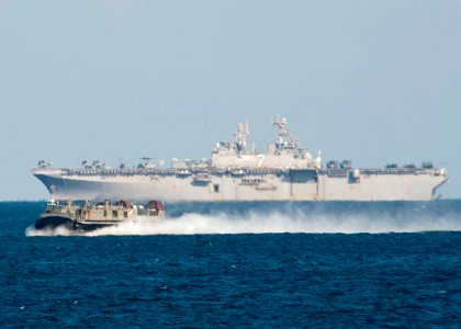 US Navy 111218-N-NR955-069 A landing craft air cushion passing the multi-purpose amphibious assault ship USS Iwo Jima (LHD 7)