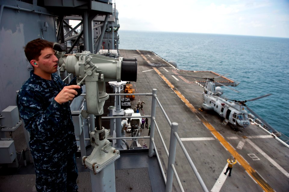US Navy 111214-N-DX615-129 Seaman Patrick Barth looks for contacts while standing the forward lookout watch aboard the amphibious assault ship USS