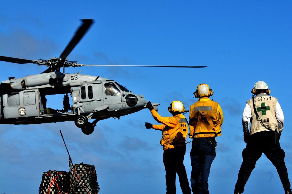 US Navy 111219-N-ZI635-366 Aviation Boatswain's Mate (Handling) 3rd Class Tamara Sewell directs an MH-60S Knight Hawk helicopter on the flight deck