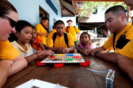 US Navy 111215-N-PB383-214 Sailors assigned to the amphibious dock landing ship USS Pearl Harbor (LSD 52) play with children during a community ser