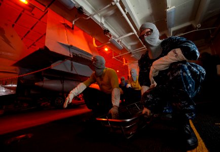 US Navy 111219-N-DR144-078 Airman Dennis Maughan and other stretcher bearers prepare to evacuate casualties during a general quarters drill in the
