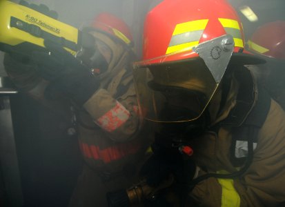 US Navy 111215-N-KA046-227 A firefighting team enters a smoke-filled room