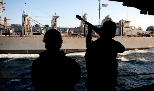 US Navy 111221-N-OY799-077 Gunner's Mate 3rd Class Cody Adams, right, fires a messenger line to the Military Sealift Command fast combat support sh