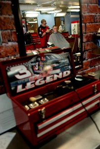 US Navy 111215-N-OY799-178 Ship's Serviceman Seaman Steven Perez cuts the hair of Aviation Ordnanceman Airman Travis McHenry in the barbershop aboa