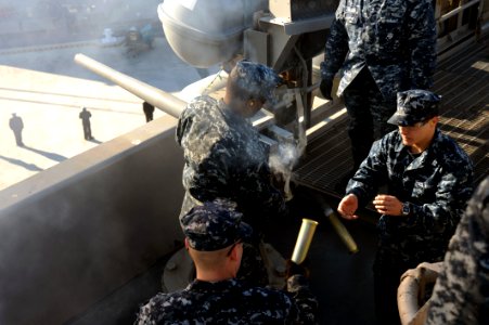 US Navy 111219-N-AU622-038 Gunner's Mate Seaman Apprentice Giacobino Imperiale prepares to load ammunition as Gunner's Mate 3rd Class Antoine Willi