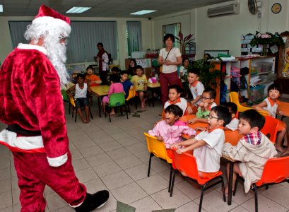 US Navy 111222-N-DX615-057 Chief Warrant Officer Marc Lefebvre, dressed as Santa Claus, greets children at Singapore's Child at Street 11 care cent