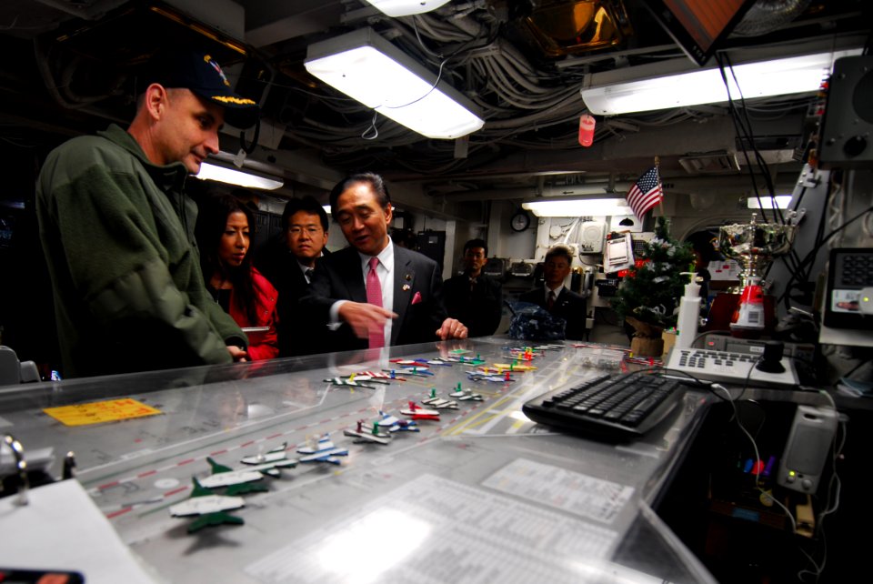 US Navy 111216-N-AW206-043 Cmdr. Wes McCall explains flight deck operations to Kanagawa Prefectural Governor Yuji Kuroiwa in flight deck control du