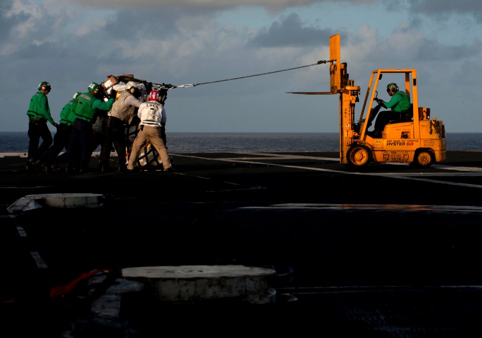 US Navy 111220-N-DR144-291 Sailors assigned to the Nimitz-class aircraft carrier USS Carl Vinson's (CVN 70) supply department move a pallet of stor