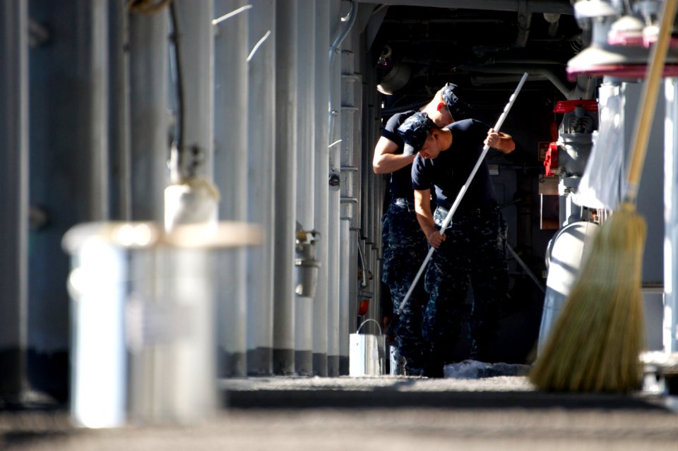 US Navy 111221-N-ZC343-052 Sailors paint the deck on the starboard catwalk aboard the amphibious assault ship USS Bonhomme Richard (LHD 6)