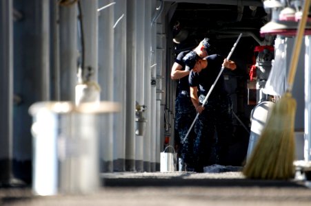 US Navy 111221-N-ZC343-052 Sailors paint the deck on the starboard catwalk aboard the amphibious assault ship USS Bonhomme Richard (LHD 6)