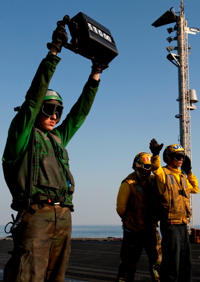 US Navy 111222-N-OY799-227 Aviation Boatswain's Mate (Equipment) Airman Matthew Fulks, left, verifies the weight of an aircraft as Sailors direct i