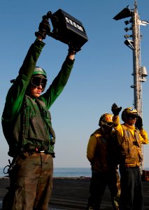 US Navy 111222-N-OY799-227 Aviation Boatswain's Mate (Equipment) Airman Matthew Fulks, left, verifies the weight of an aircraft as Sailors direct i