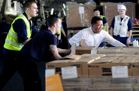 US Navy 111221-N-RG587-127 Chief Warrant Officer Loreto A. Lagrisola helps Sailors organize pallets of food in the hangar bay during a replenishmen