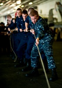 US Navy 111221-N-BT887-064 Cryptologic Technician (Collection) Seaman Kyle Kinderwater heaves a line for a sliding pad eye aboard the Nimitz-class