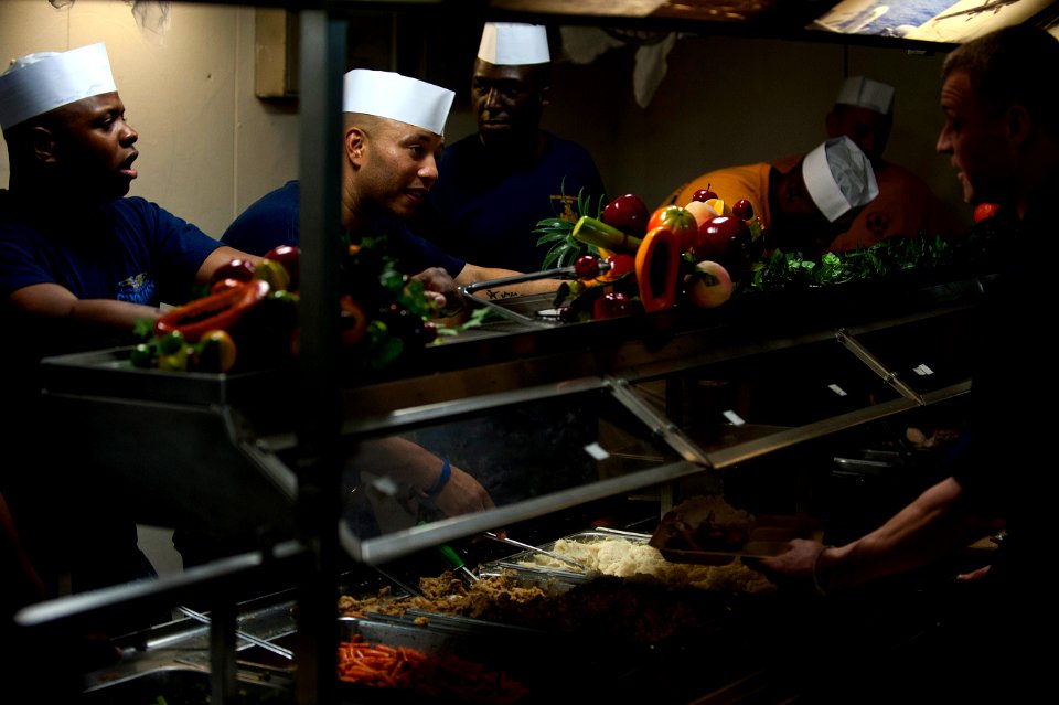 US Navy 111225-N-DR144-131 Chief petty officers serve Christmas dinner to junior enlisted Sailors on the mess decks aboard the Nimitz-class aircraf