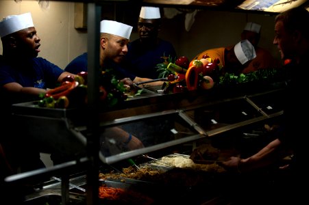 US Navy 111225-N-DR144-131 Chief petty officers serve Christmas dinner to junior enlisted Sailors on the mess decks aboard the Nimitz-class aircraf