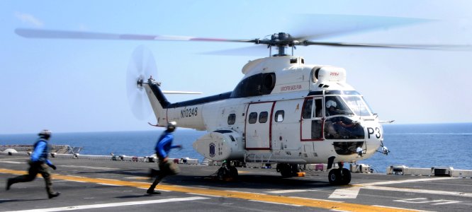 US Navy 111223-N-KA046-051 Aviation boatswain's mate handlers sprint to unchain an SA-330J Puma helicopter assigned to the Military Sealift Command