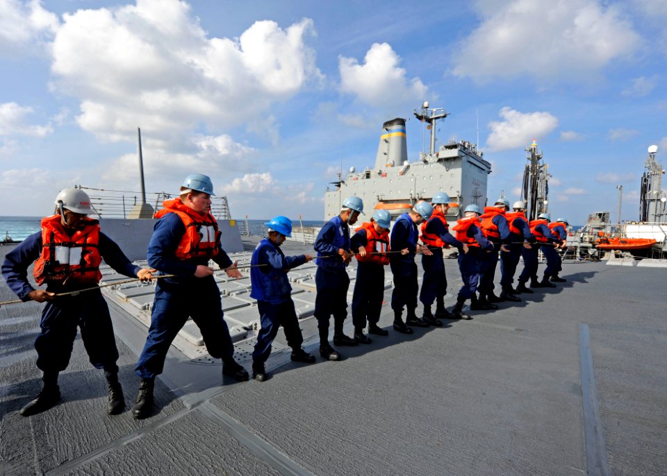 US Navy 111221-N-VH839-003 Sailors aboard the Arleigh Burke-class guided-missile destroyer USS Dewey (DDG 105) heave a line connected to a fueling