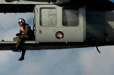 US Navy 111220-N-DR144-761 A Naval Air Crewman assigned to Helicopter Sea Combat Squadron (HSC) 12 guides the pilots of an MH-60S Sea Hawk helicopt