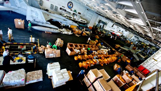 US Navy 111221-N-OY799-418 Sailors sort cargo in the hangar bay aboard the Nimitz-class aircraft carrier USS John C. Stennis (CVN 74)