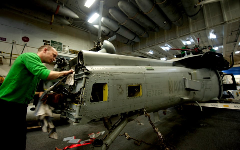 US Navy 111228-N-OY799-058 Aviation Electronics Technician 3rd Class Stephen Hesch, from Laughlin, Nev., cleans grease off the tail rotor on an MH