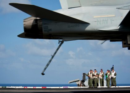 US Navy 111222-N-DR144-395 Landing signal officers supervise the arrested recovery of an F-A-18C Hornet on the flight deck aboard the Nimitz-class