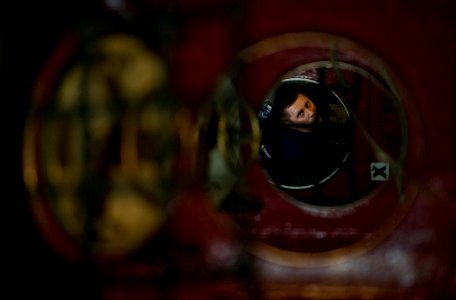 US Navy 111223-N-DR144-195 Interior Communications Electrician Fireman Michael Liermann ascends an access trunk after completing maintenance on the