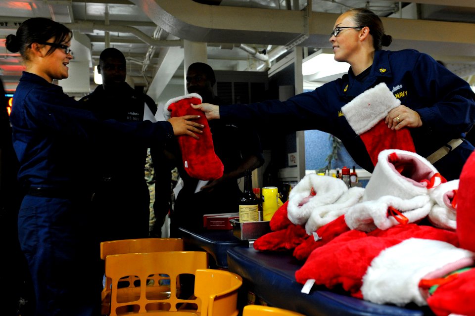 US Navy 111222-N-KS651-091 Personnel Specialist Chief Janna Mason hands out Christmas stockings to single Sailors on the mess decks of dock landing
